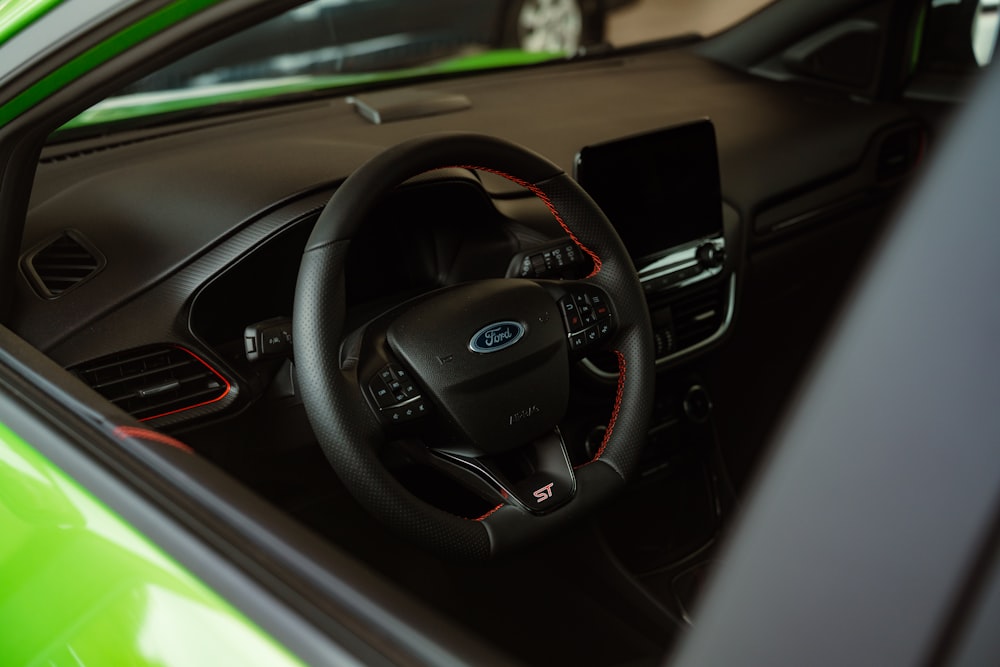 the interior of a green car with a steering wheel