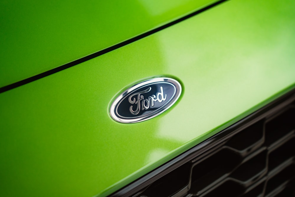 a close up of the emblem on the front of a green car