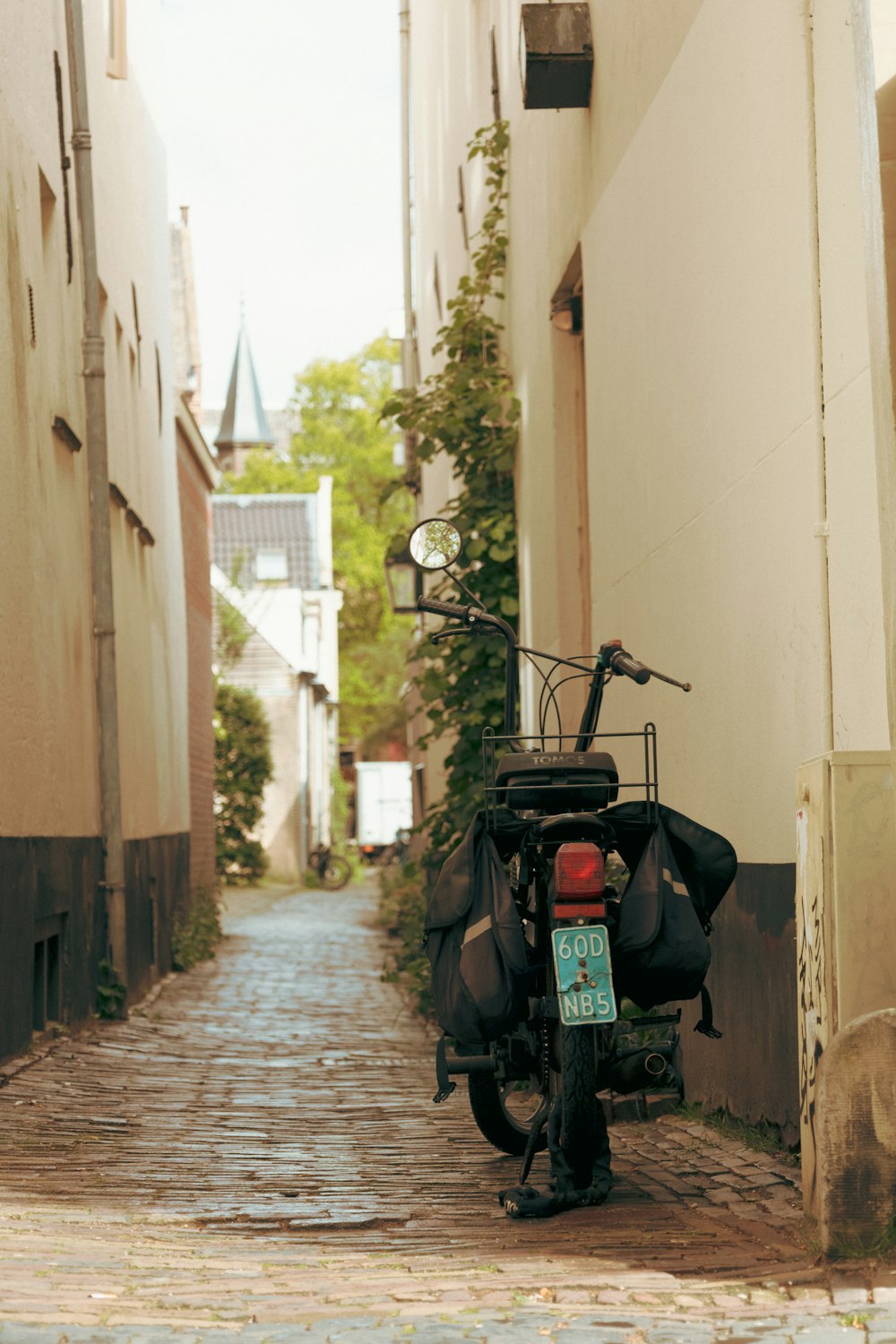 a motorcycle parked on the side of a narrow street