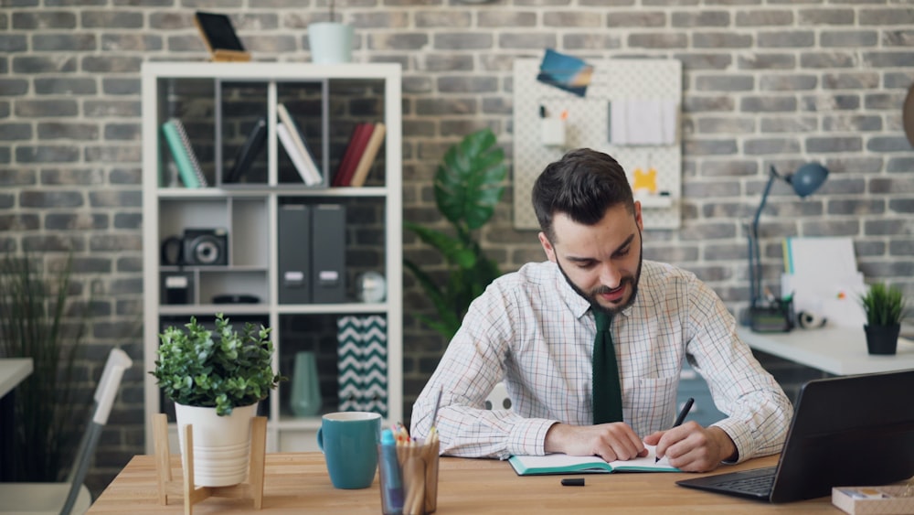 a man sitting at a desk working on a laptop