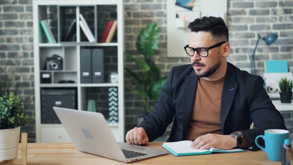 a man sitting at a table using a laptop computer