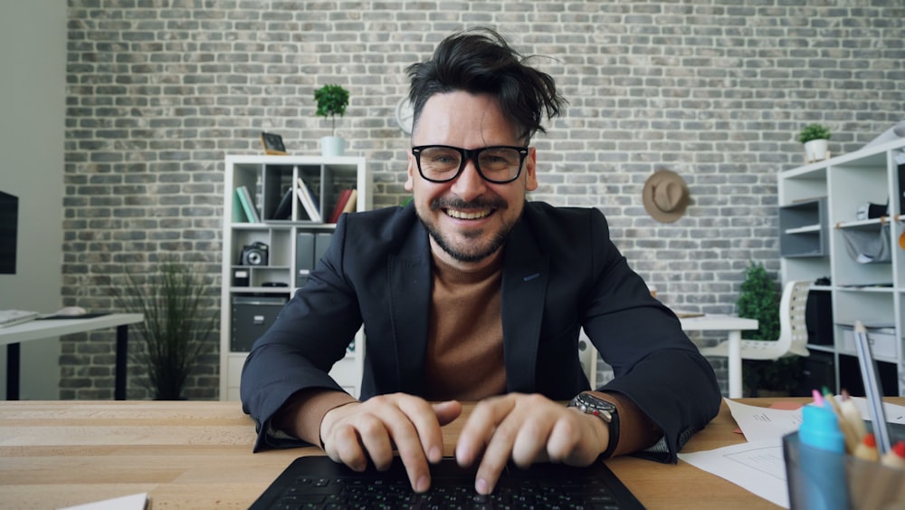 a man sitting at a table with a laptop computer