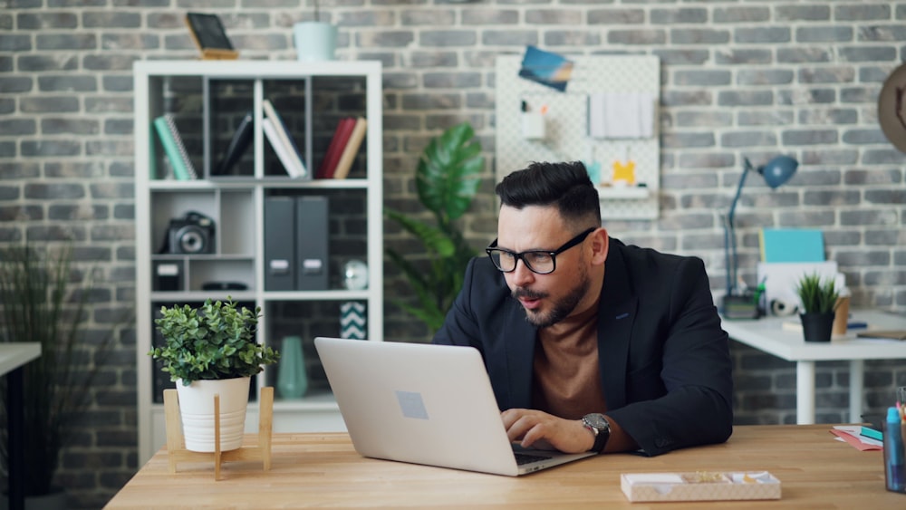 a man sitting at a table using a laptop computer