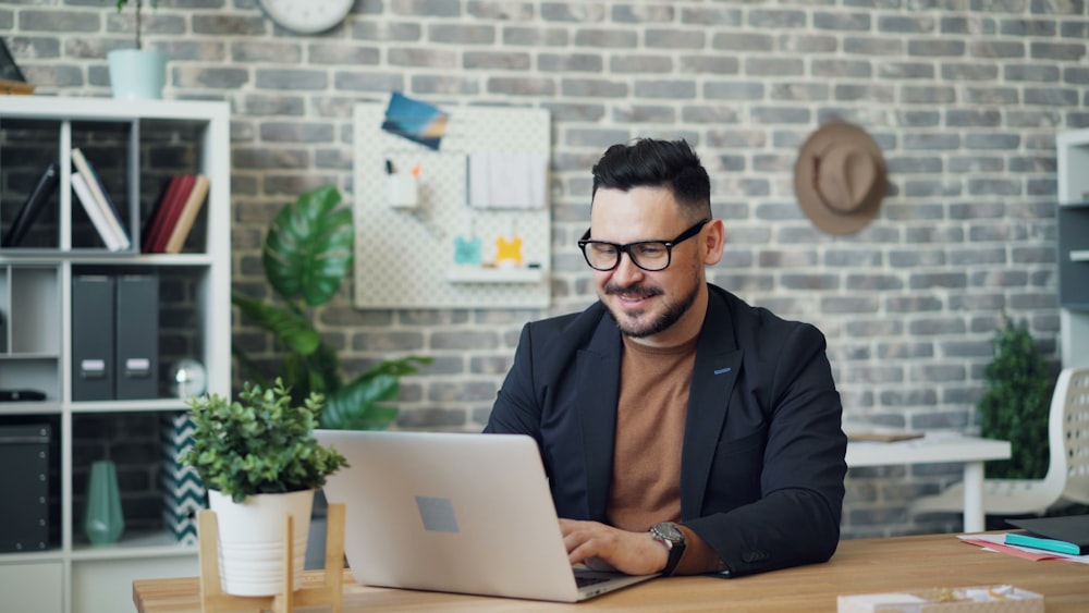 a man sitting at a desk using a laptop computer