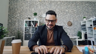 a man sitting at a table using a laptop computer