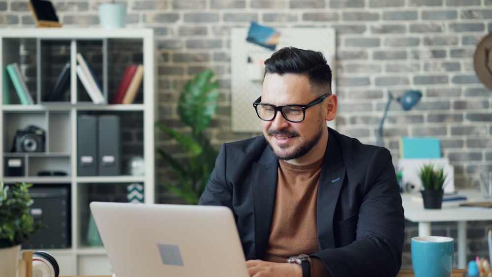 a man sitting at a desk using a laptop computer