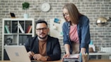 a man and a woman looking at a laptop