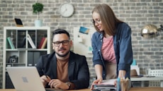 a man and a woman looking at a laptop