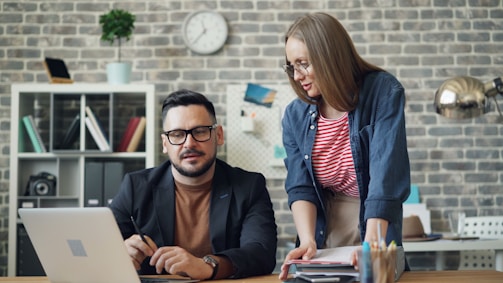 a man and a woman looking at a laptop