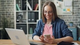 a woman sitting at a table looking at her cell phone