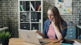 a woman sitting at a table using a laptop computer