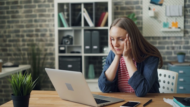 a woman after 40 fatigue and sitting at a table with a laptop in front of her