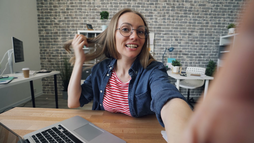 a woman sitting at a table in front of a laptop computer