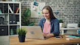 a woman sitting at a desk using a laptop computer