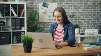 a woman sitting at a desk using a laptop computer