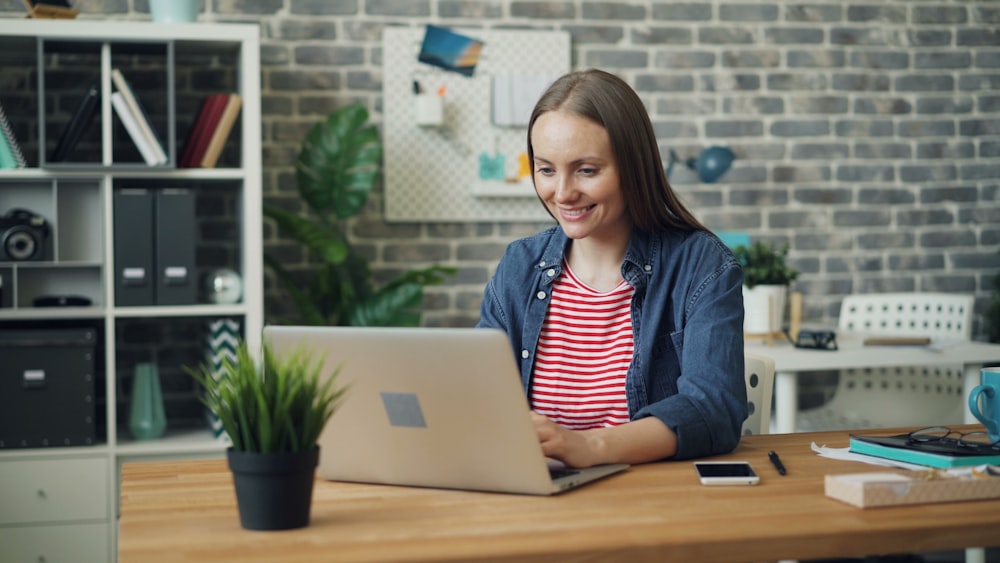 a woman sitting at a desk using a laptop computer