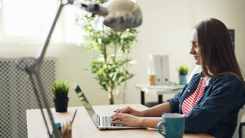 a woman sitting at a desk using a laptop computer