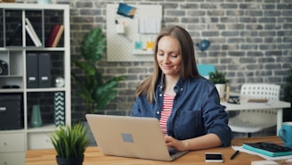 a woman sitting at a desk using a laptop computer
