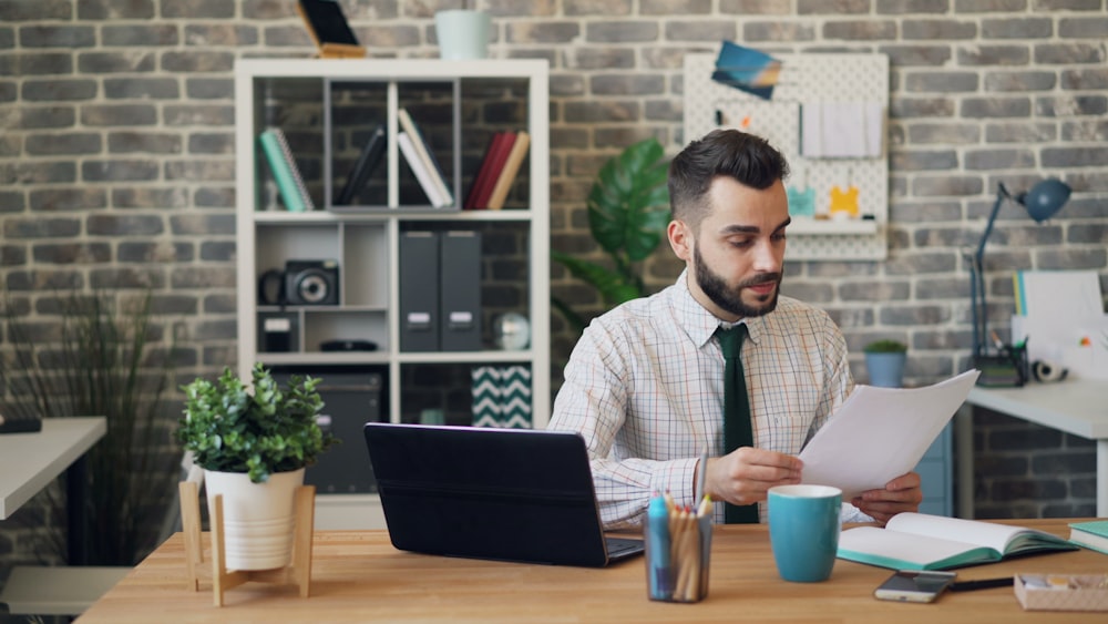 a man sitting at a desk in front of a laptop