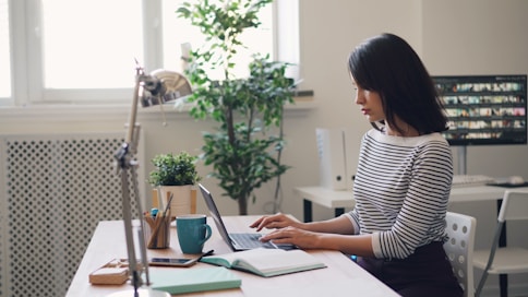 a woman sitting at a desk using a laptop computer