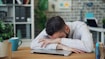 a man sitting at a desk with his head in his hands