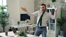 a man in a tie is dancing in an office