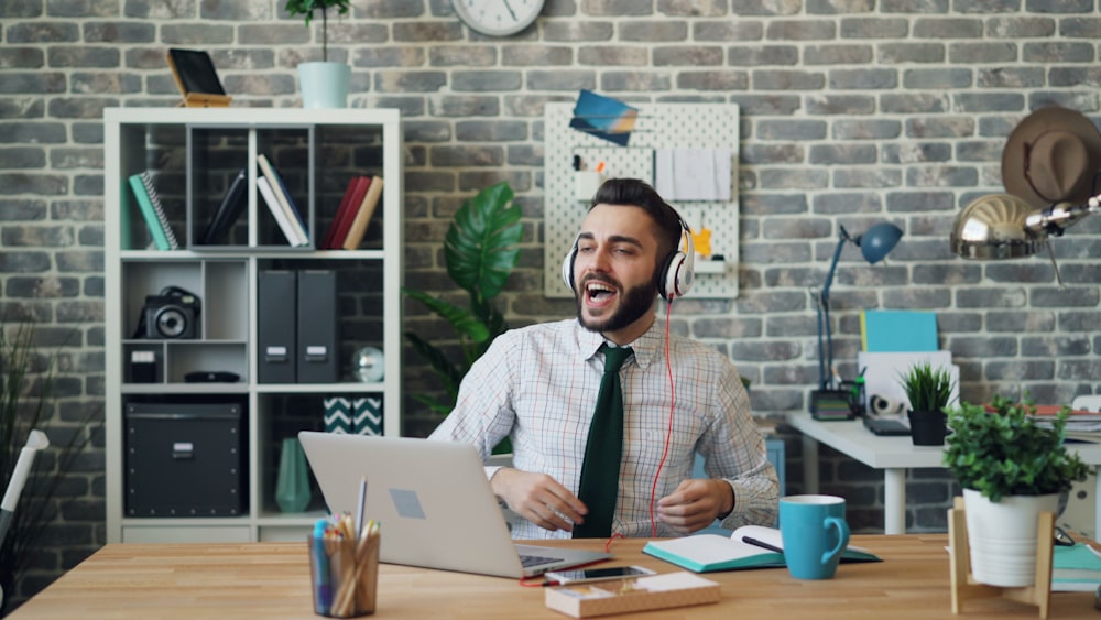 a man sitting at a desk in front of a laptop