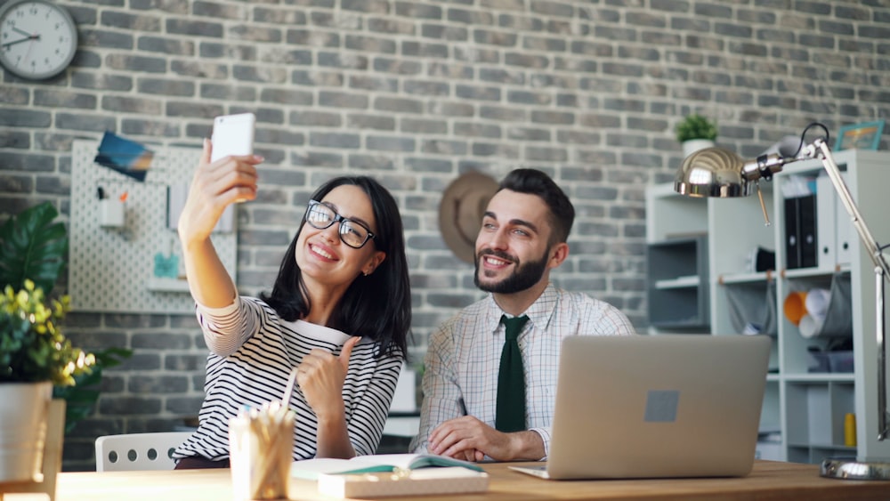 a man and a woman sitting at a table with a laptop