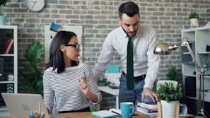 a man and a woman standing in front of a laptop