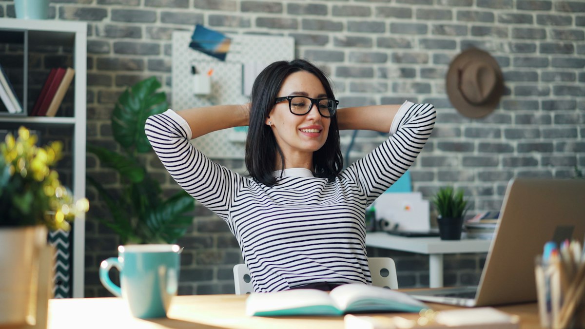 A person taking a stretching break at their desk to ease forearm and wrist tension from typing