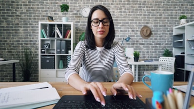 a woman sitting at a desk using a laptop computer