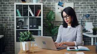 a woman sitting at a desk using a laptop computer