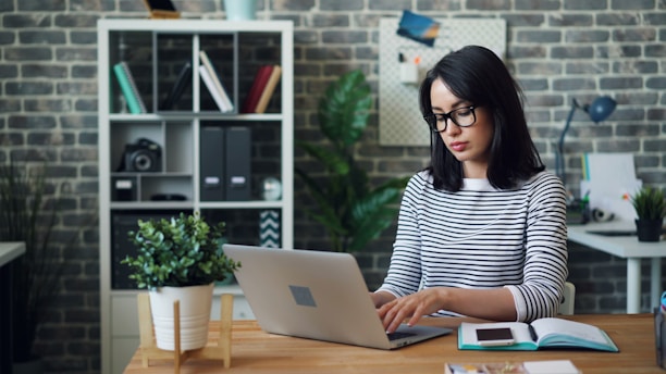 a woman sitting at a desk using a laptop computer