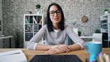 a woman sitting at a desk in front of a laptop