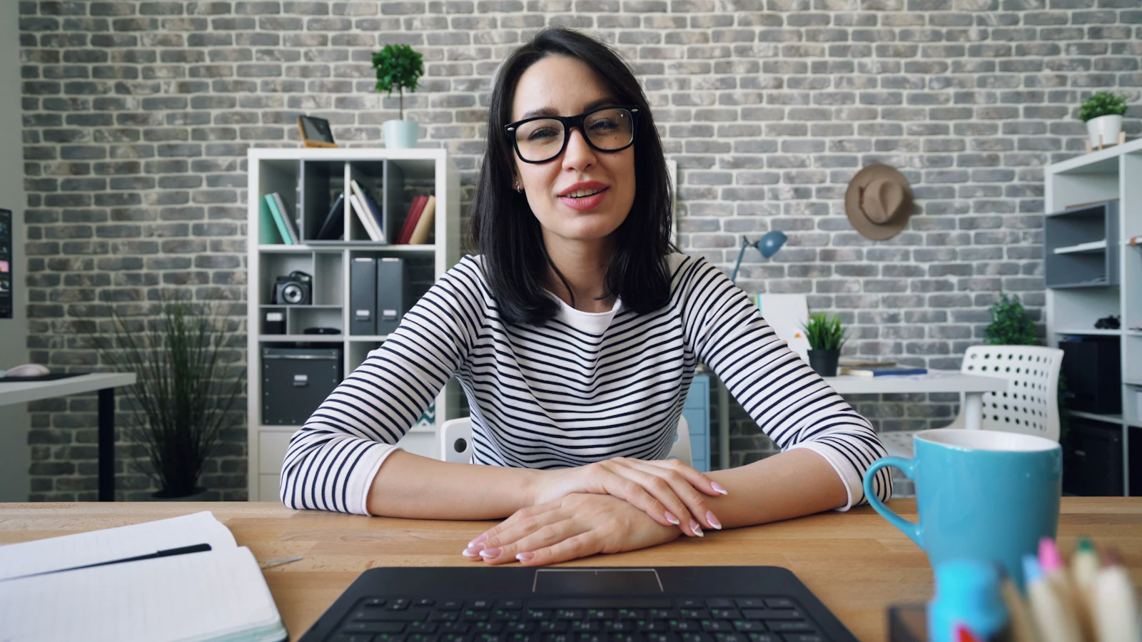A woman at a desk in front of a laptop