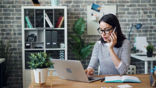 a woman sitting at a desk using a laptop computer