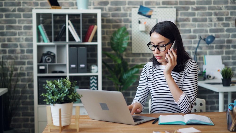 una mujer sentada en un escritorio usando una computadora portátil