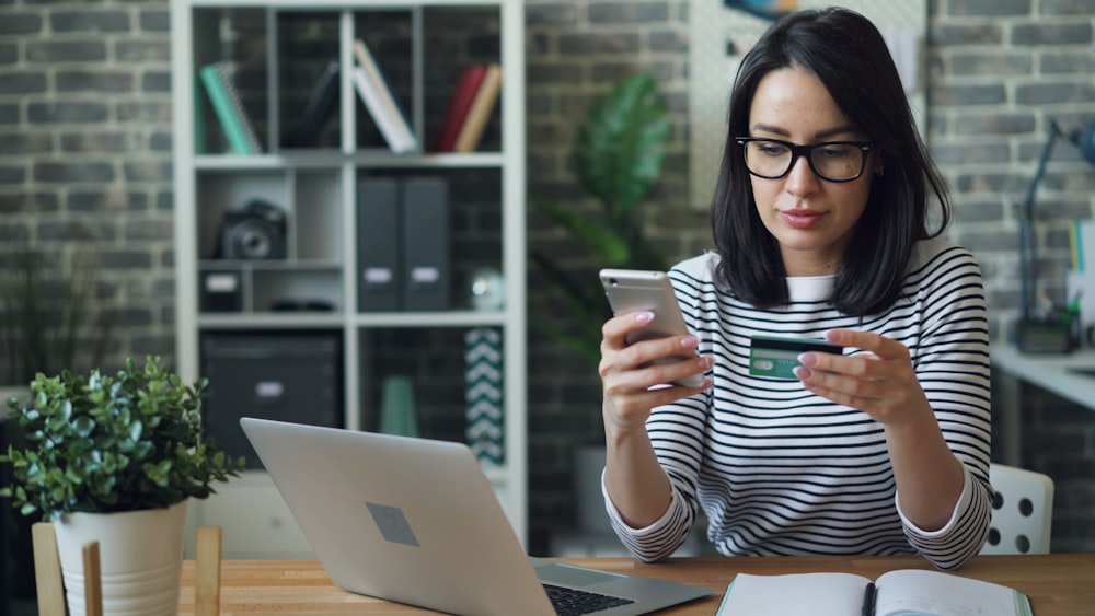 a woman sitting at a table looking at her cell phone