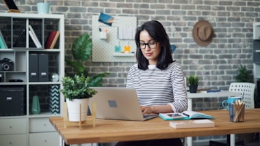 a woman sitting at a desk using a laptop computer