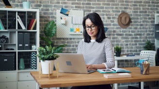 a woman sitting at a desk using a laptop computer