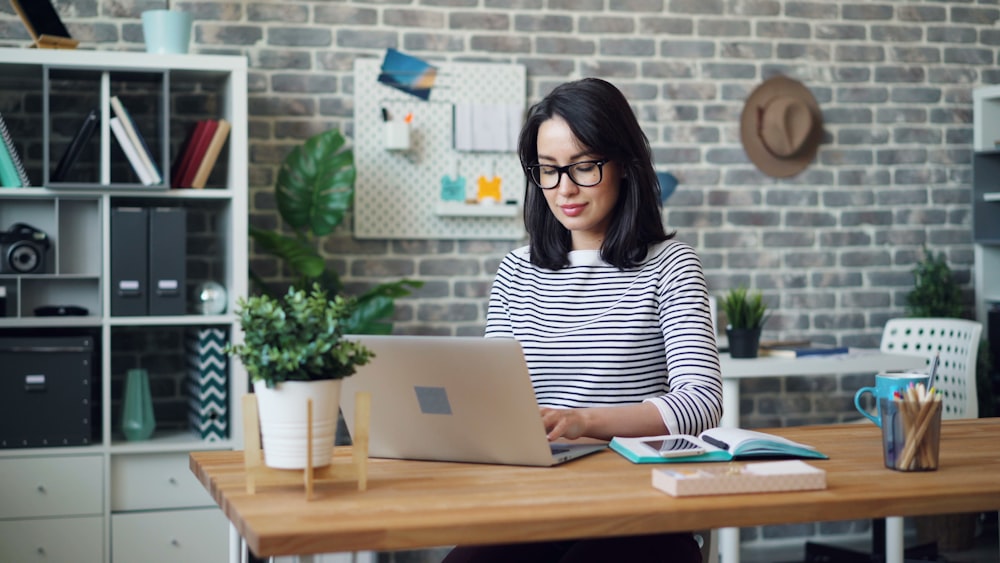 a woman sitting at a desk using a laptop computer