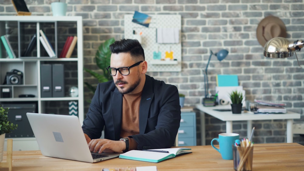 a man sitting at a table using a laptop computer