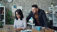 a man and a woman looking at a laptop