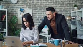 a man and a woman looking at a laptop