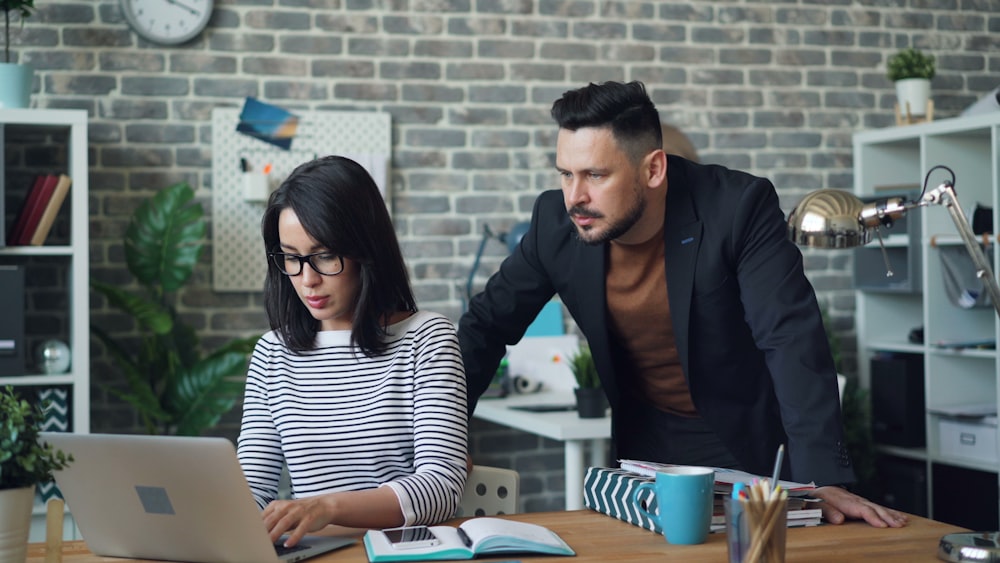 a man and a woman looking at a laptop