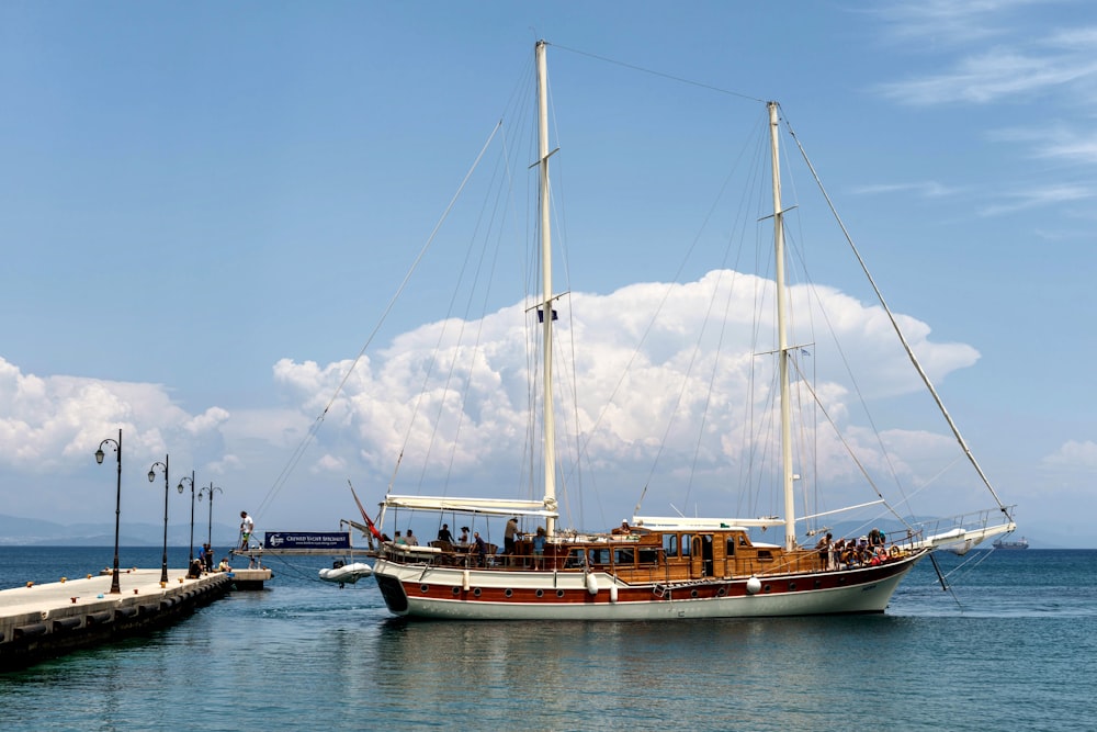 a sailboat in the water next to a dock