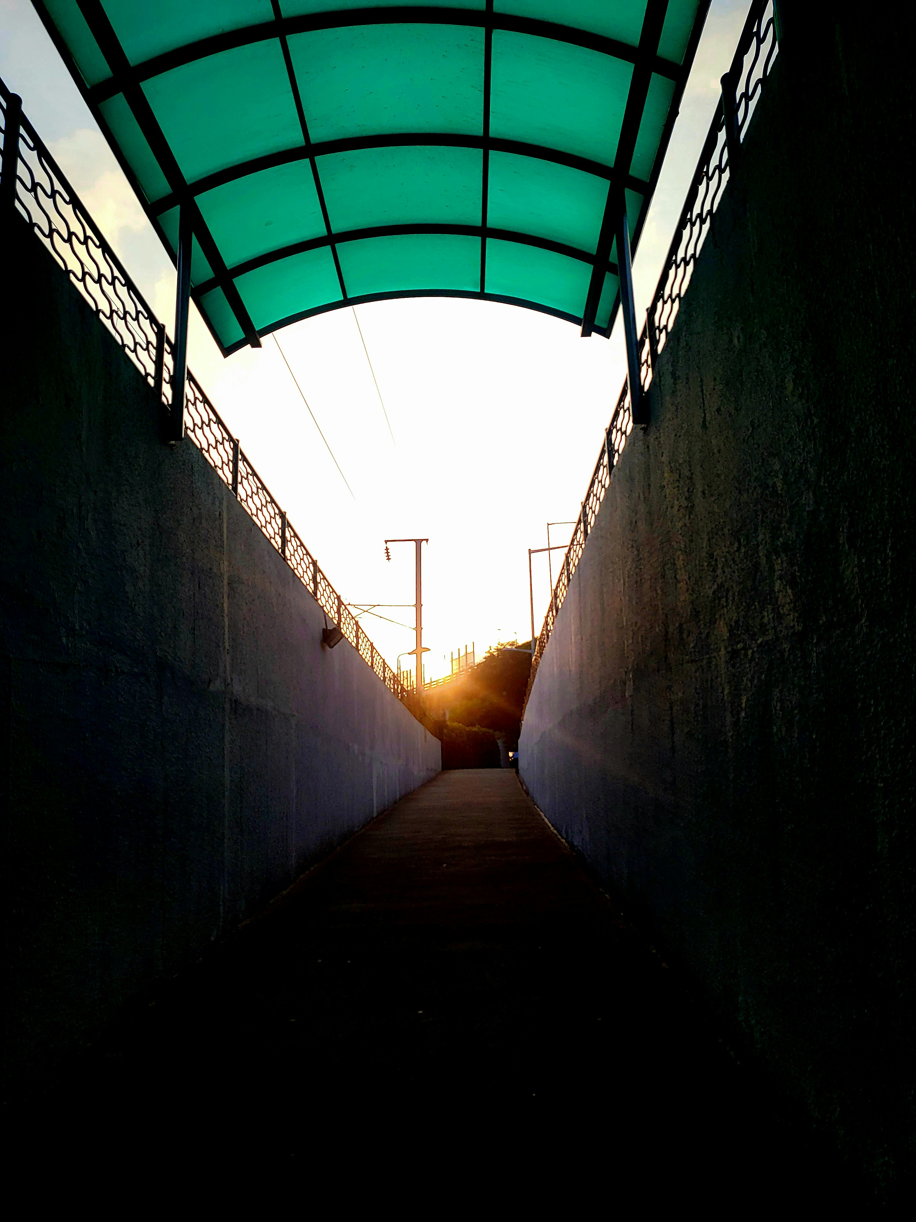the sun is setting in the distance behind a tunnel