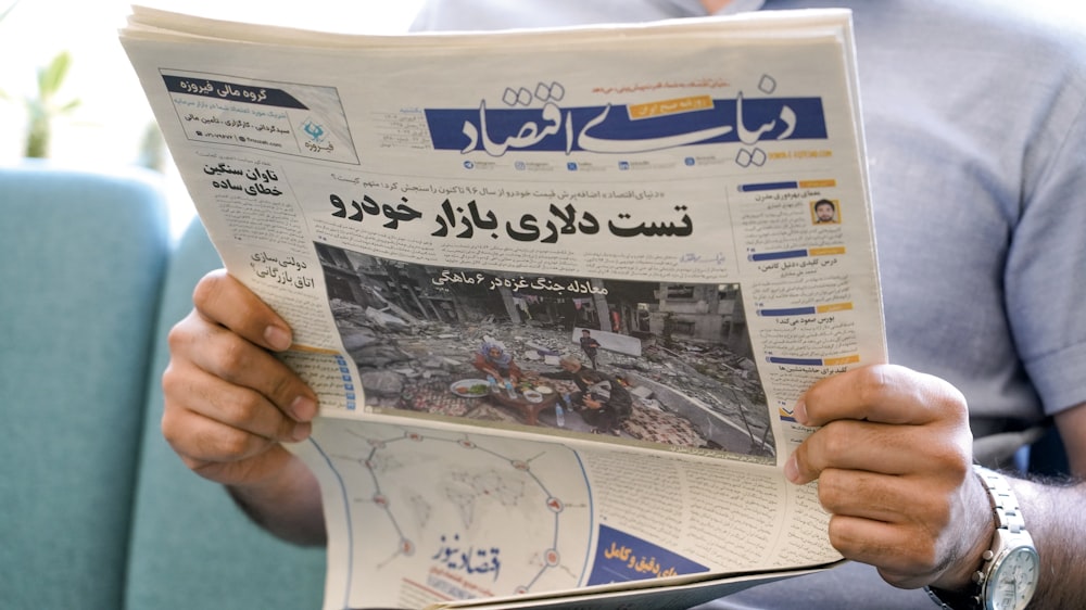 a man holding a newspaper with a picture of a man on it