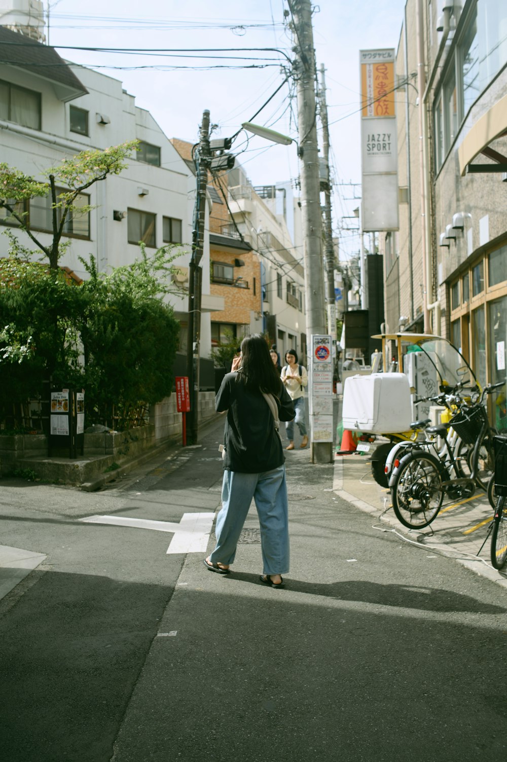 uma mulher em pé em uma esquina falando ao celular