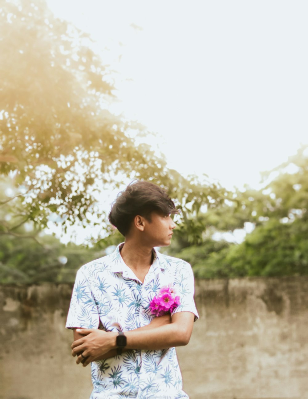 a man holding a pink flower in his hand